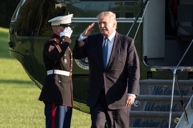 US President Donald Trump salutes as he steps off Marine One in Washington, DC