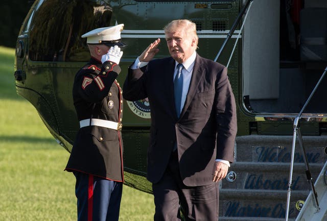 US President Donald Trump salutes as he steps off Marine One in Washington, DC