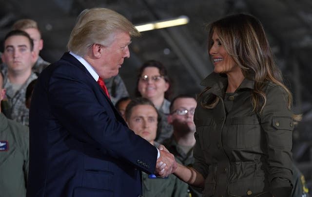 US President Donald Trump shakes hands with First Lady Melania Trump after she spoke to members of the military