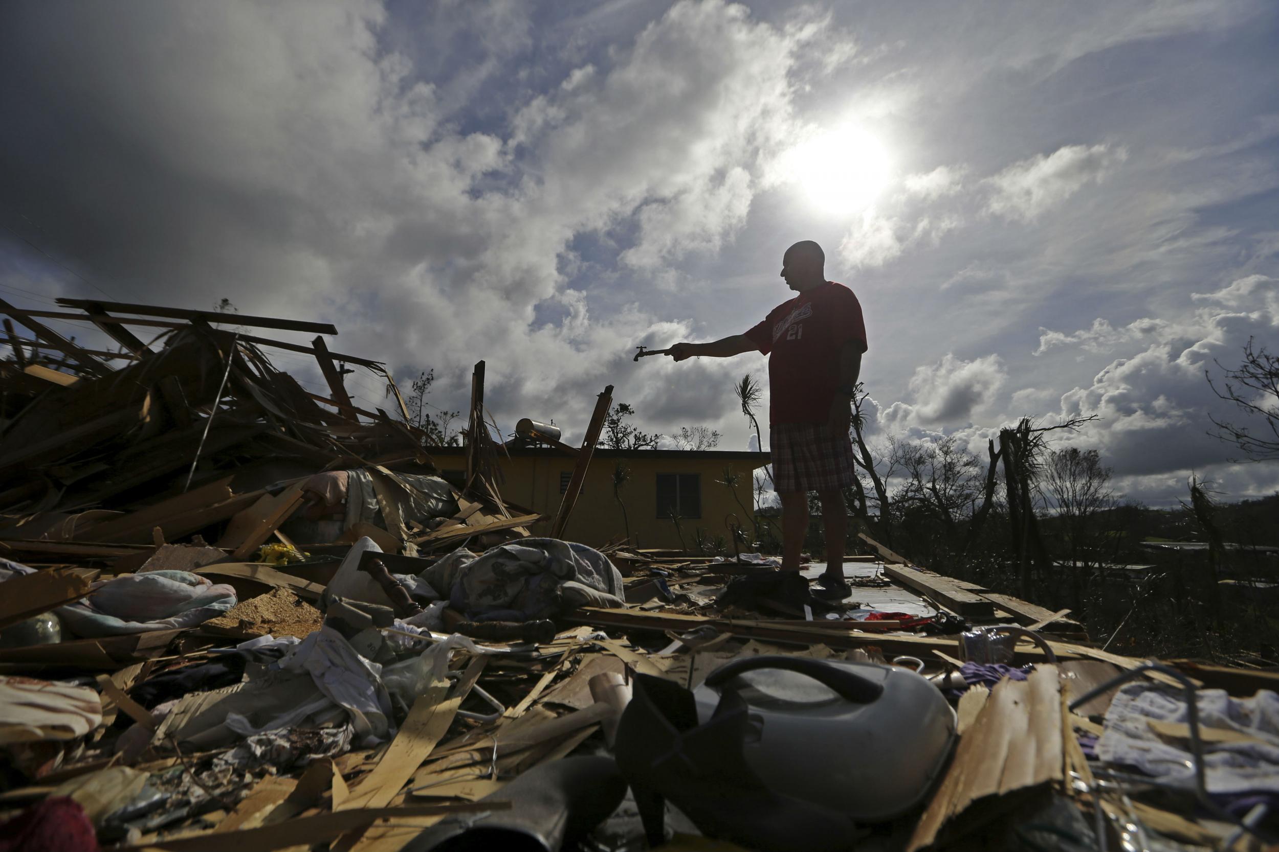 A Puerto Rican man amid the remains of his destroyed home in Aibonito, Puerto Rico on Monday, Sept. 25, 2017. Mr Trump plans to visit the island