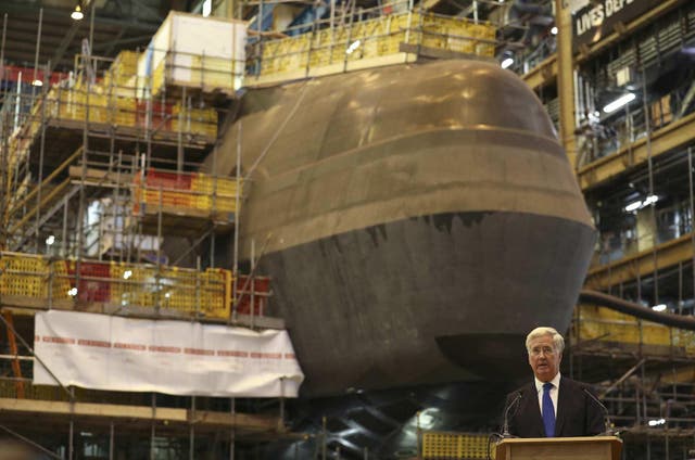 Britain's Defence Secretary Michael Fallon speaks to workers after watching the first piece of steel for the successor submarine programme being cut at BAE Systems on October 5, 2016  in Barrow-In-Furness, United Kingdom