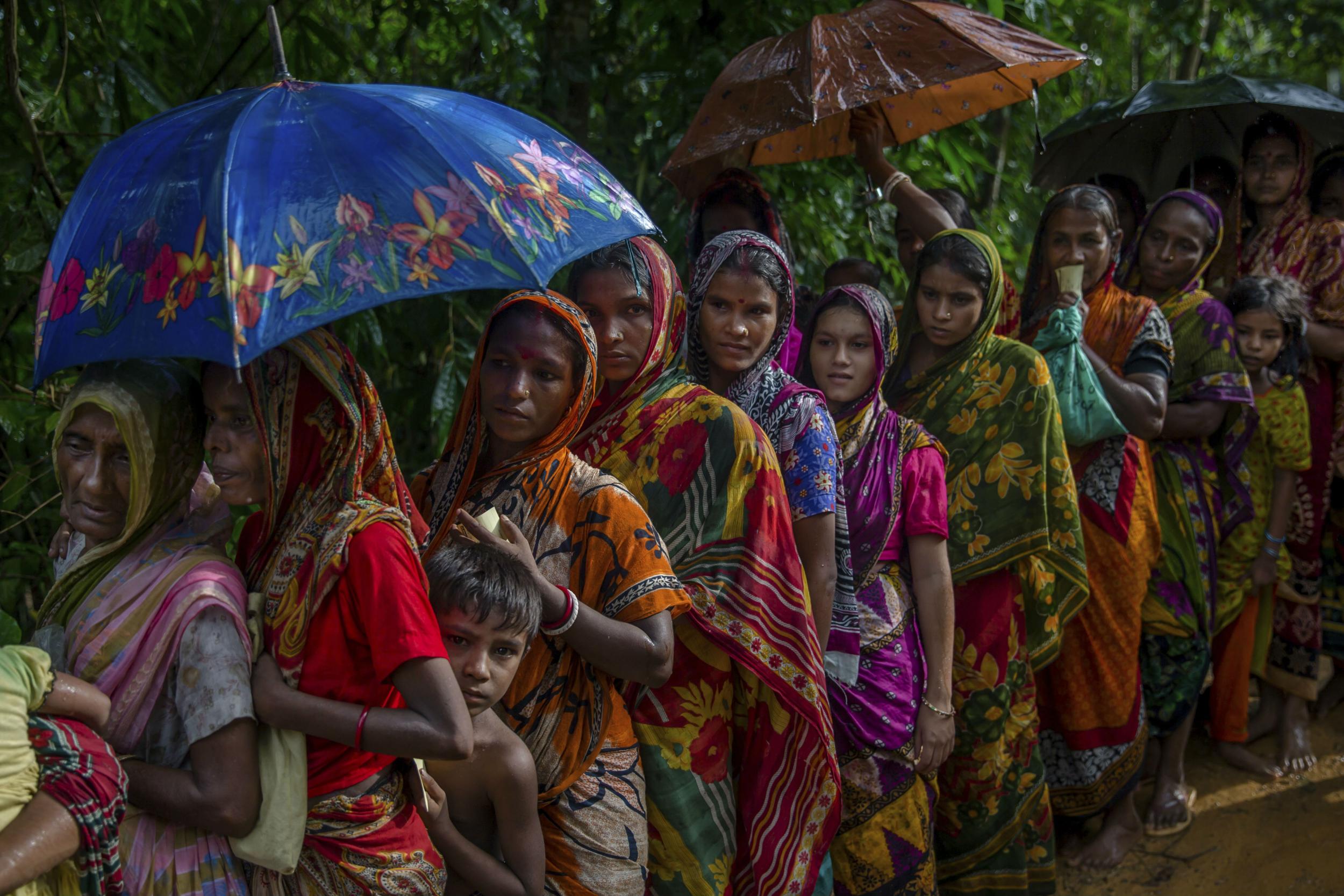 Men and women wait for their turn to collect aid at refugee camp set up for Hindu refugees near Kutupalong, Bangladesh on Sept. 26, 2017