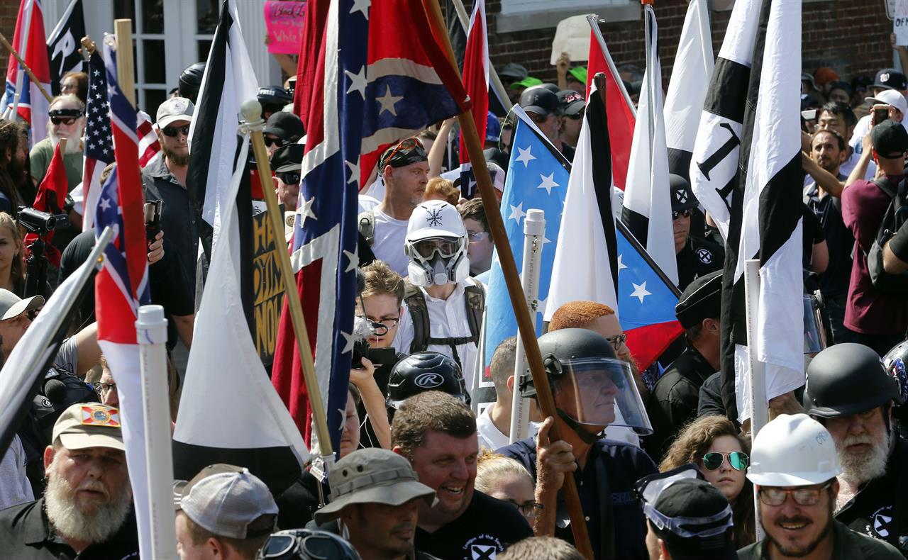 White nationalist demonstrators walk into the entrance of Lee Park surrounded by counter demonstrators on 12 August 2017 in Charlottesville