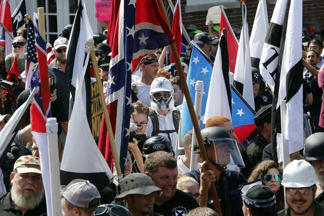 White nationalist demonstrators walk into the entrance of Lee Park surrounded by counter demonstrators on 12 August 2017 in Charlottesville