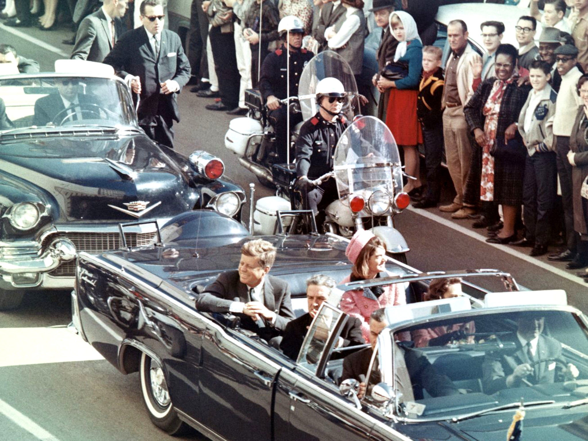 JFK and his wife Jackie ride in the motorcade shortly before his assassination