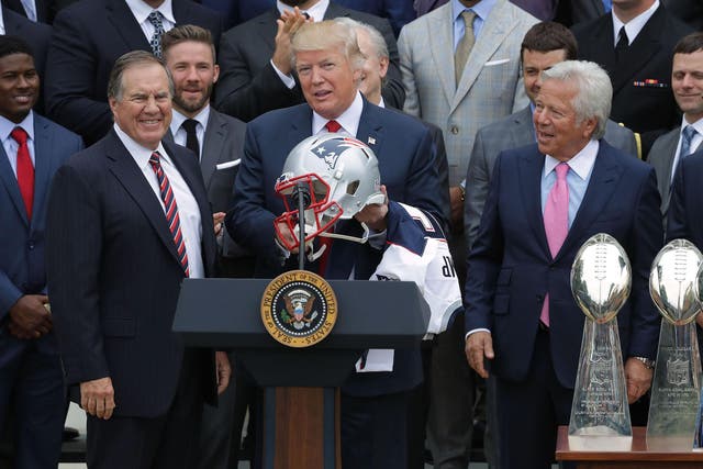 New England Patriots Head Coach Bill Belichick (L) and team owner Robert Kraft (R) present a football helmet to U.S. President Donald Trump during a celebration of the team's Super Bowl victory on the South Lawn at the White House April 19, 2017 in Washington