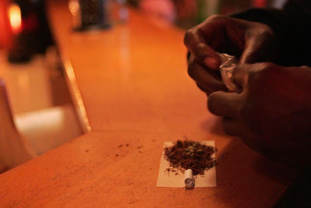 A customer rolls a joint at a coffeeshop in Rosendaal, a Dutch town where the mayor has taken the controversial decision to shut down four such cannabis cafés