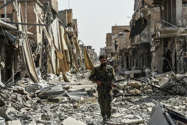 A member of the Syrian Democratic Forces walks through the debris in the old city centre on the eastern frontline of Raqqa on 25 September 2017