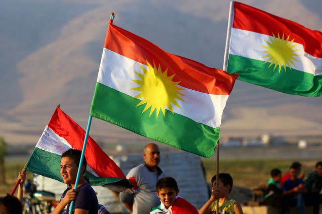 Syrian Kurds wave the Kurdish flag, in the northeastern Syrian city of Qamishli on September 27 during a gathering in support of the independence referendum