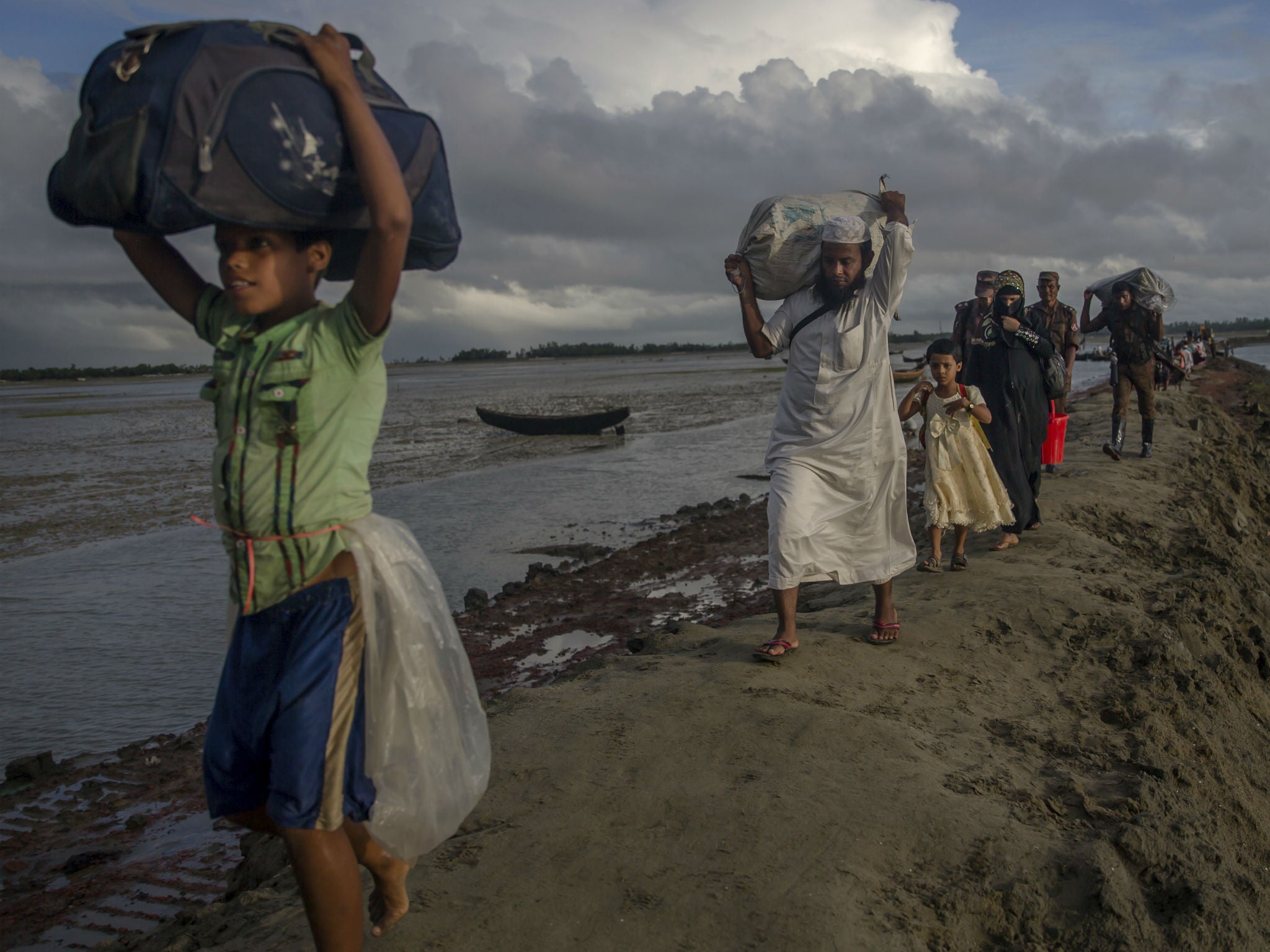 Newly-arrived Rohingya Muslims, who crossed over from Burma into Bangladesh, walk towards the nearest refugee camp at Teknaf
