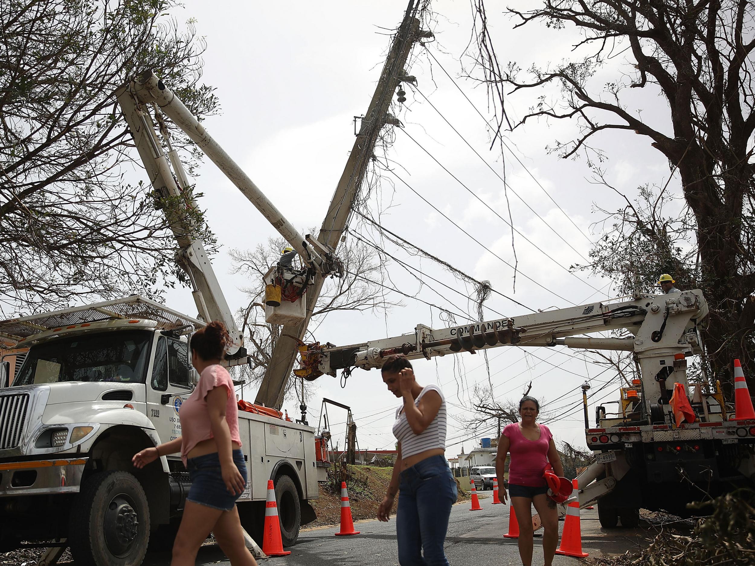 An electrical crew attempts to repair power lines that were knocked over Hurricane Maria passed through on 27 September, 2017 in Corozal, Puerto Rico