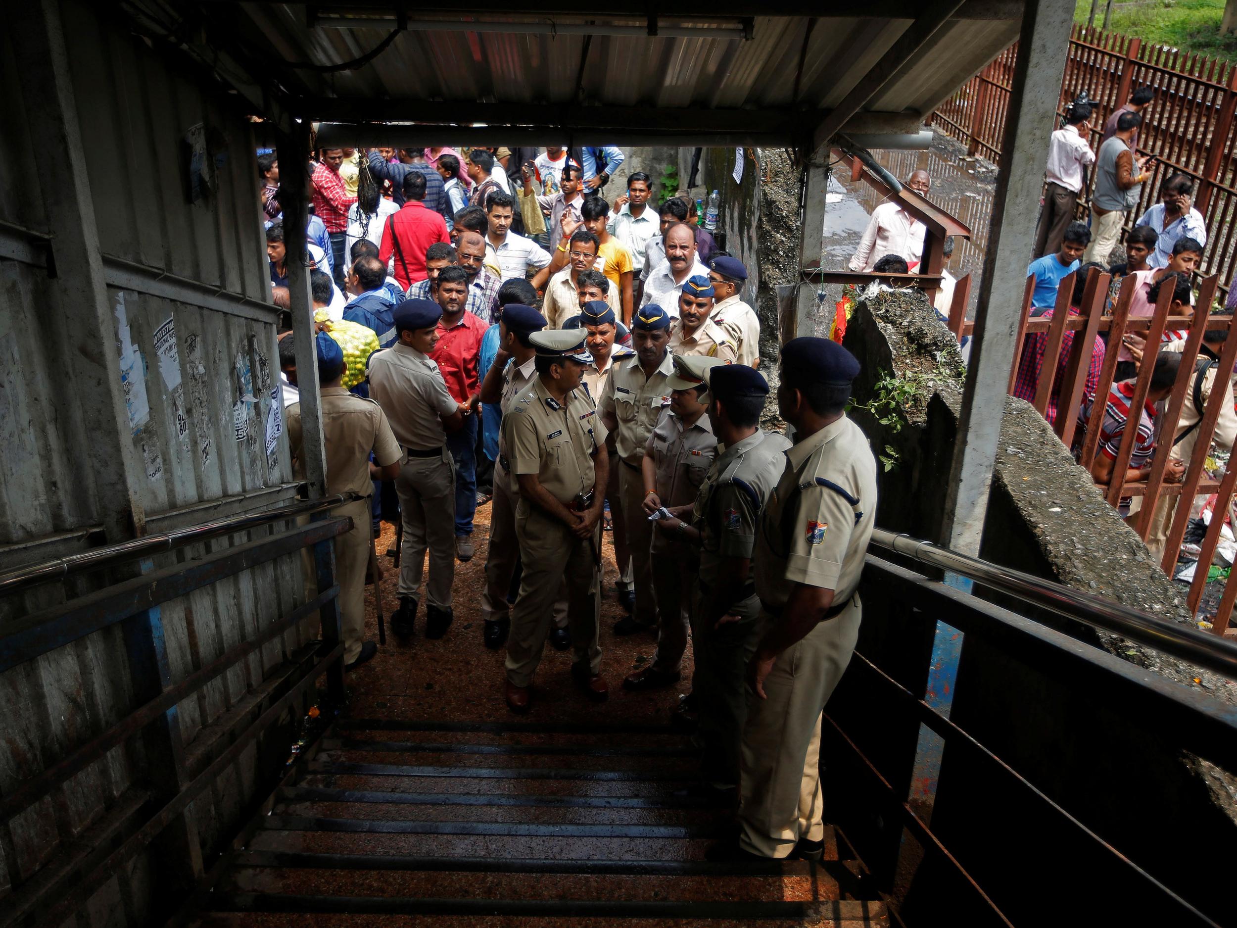 Policemen inspect the site of a stampede at a railway station's pedestrian overbridge in Mumbai, India September 29, 2017