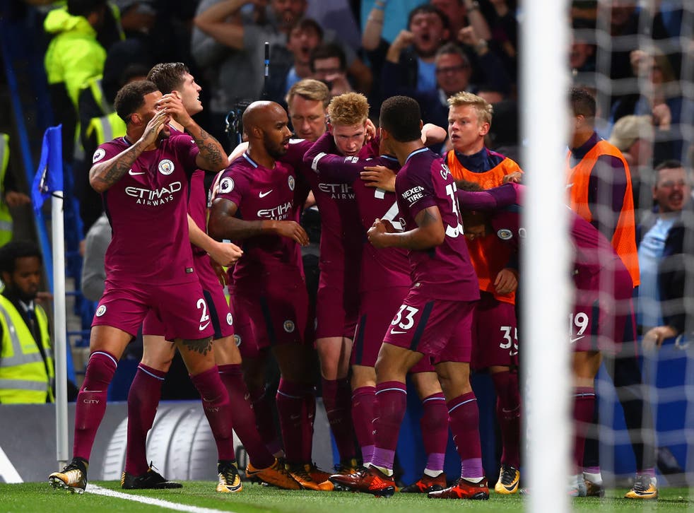Kevin de Bruyne is swamped by his teammates after scoring the winner for Manchester City