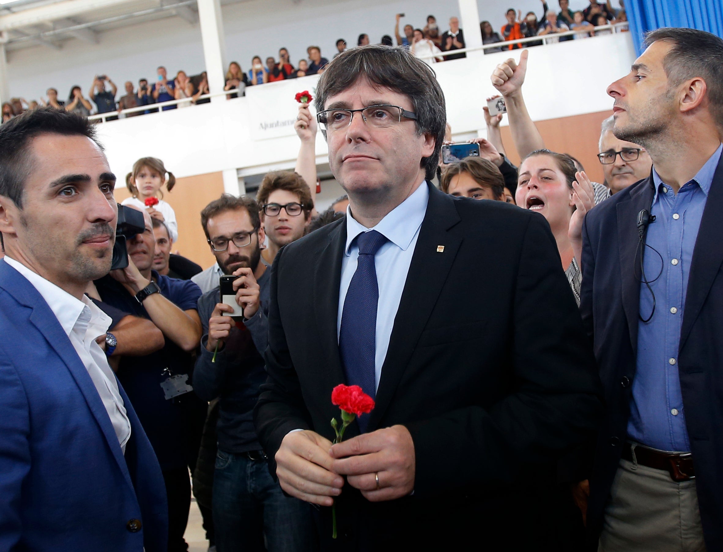 Catalan President Carles Puigdemont arrives to talk to the media at a sports center, assigned to be a polling station by the Catalan government