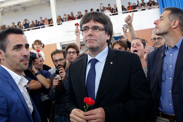 Catalan President Carles Puigdemont arrives to talk to the media at a sports center, assigned to be a polling station by the Catalan government
