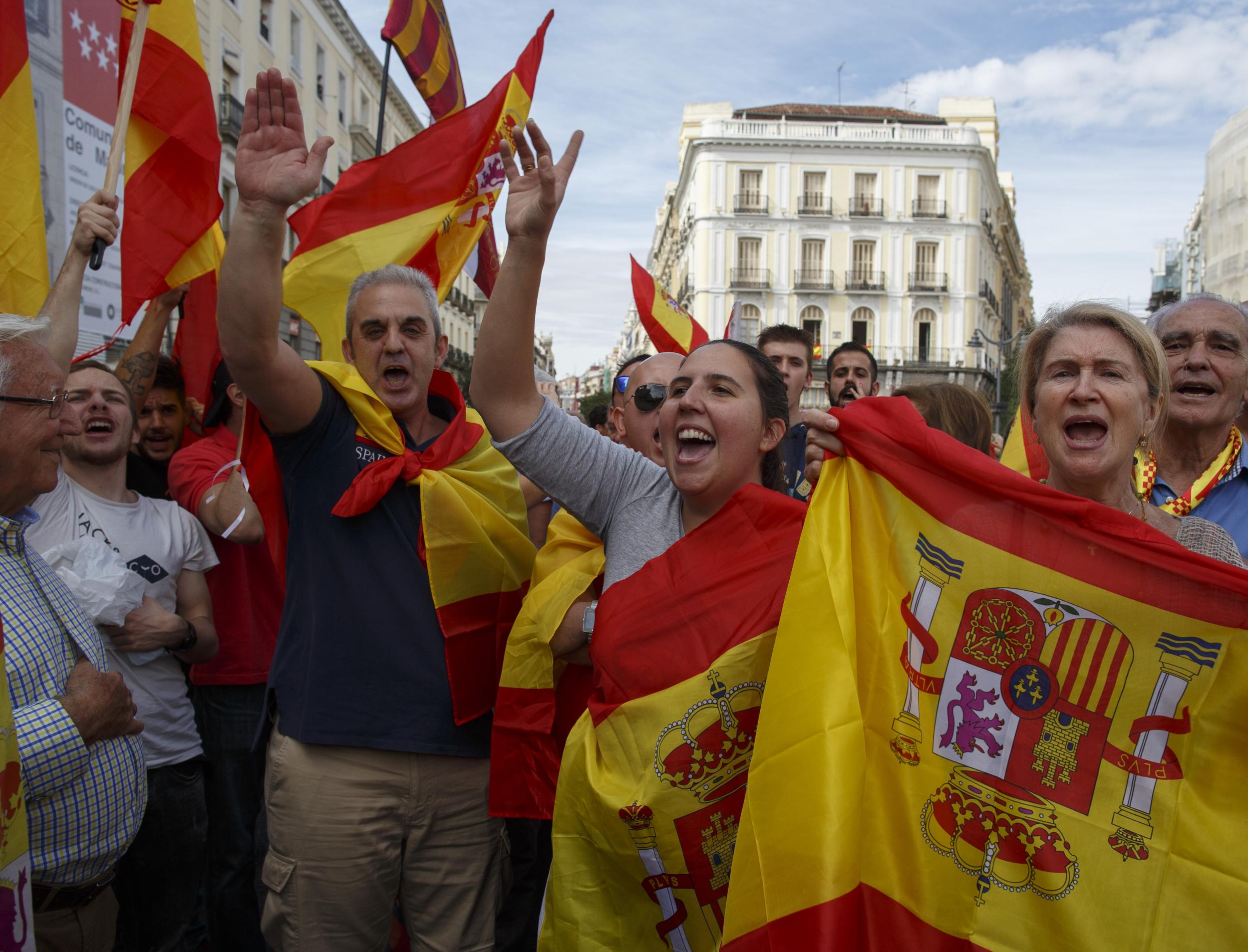 Anti-separatist demonstrators hold Spanish flags and shout slogans as one does a fascist salute during a protest in support of Spain's unity