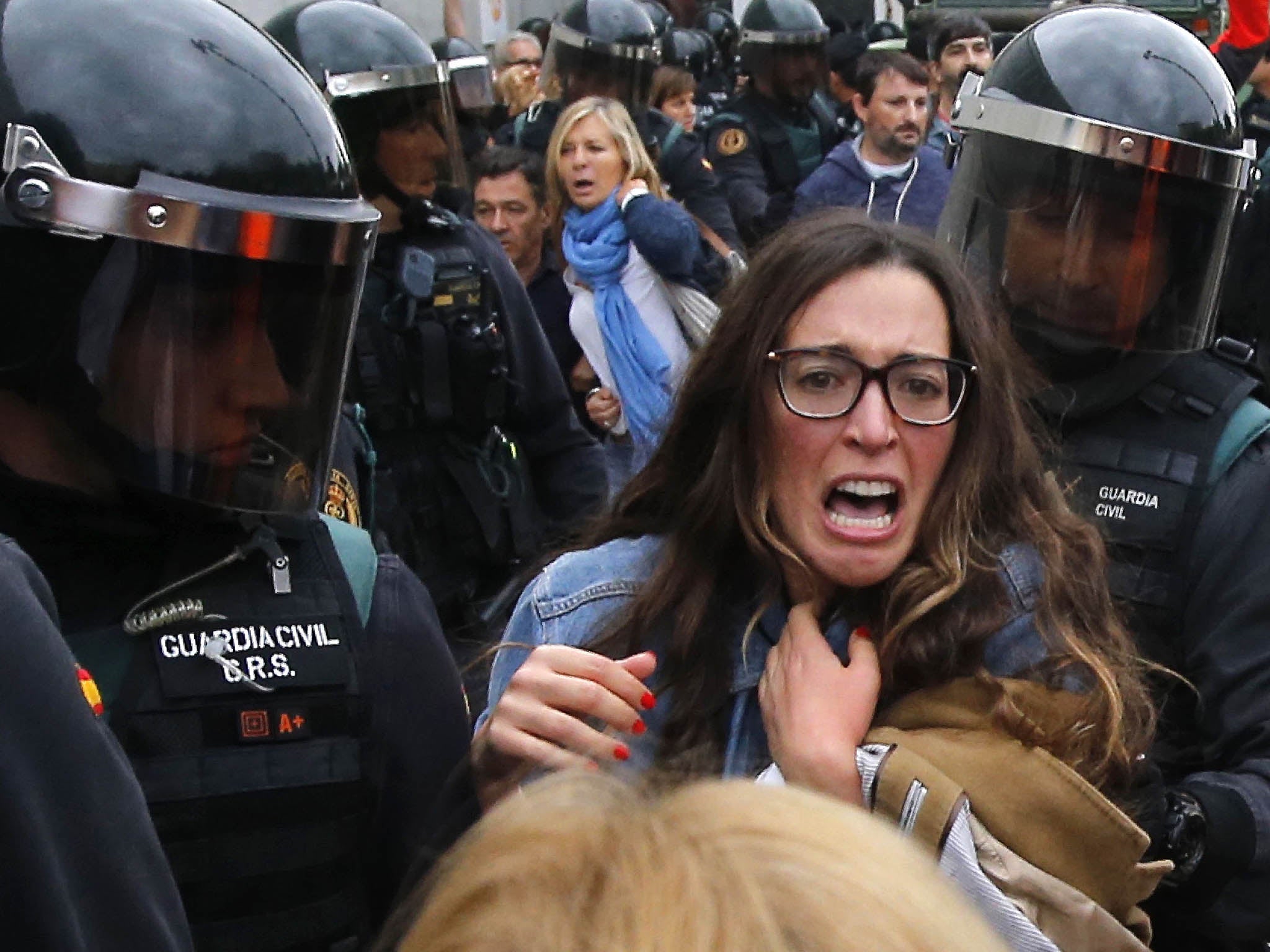 A protester is grabbed by the Civil Guard in the village of Sant Julia de Ramis where the Catalan President was due to vote