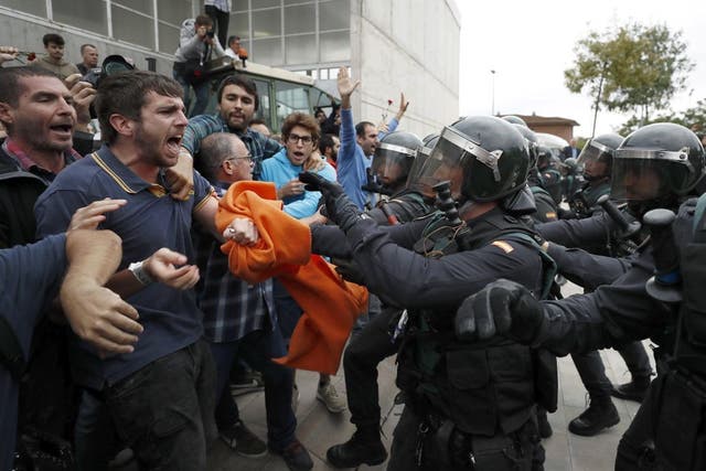 Pro-independence protesters clash with the Civil Guard outside a sports centre doubling as a polling station in Girona