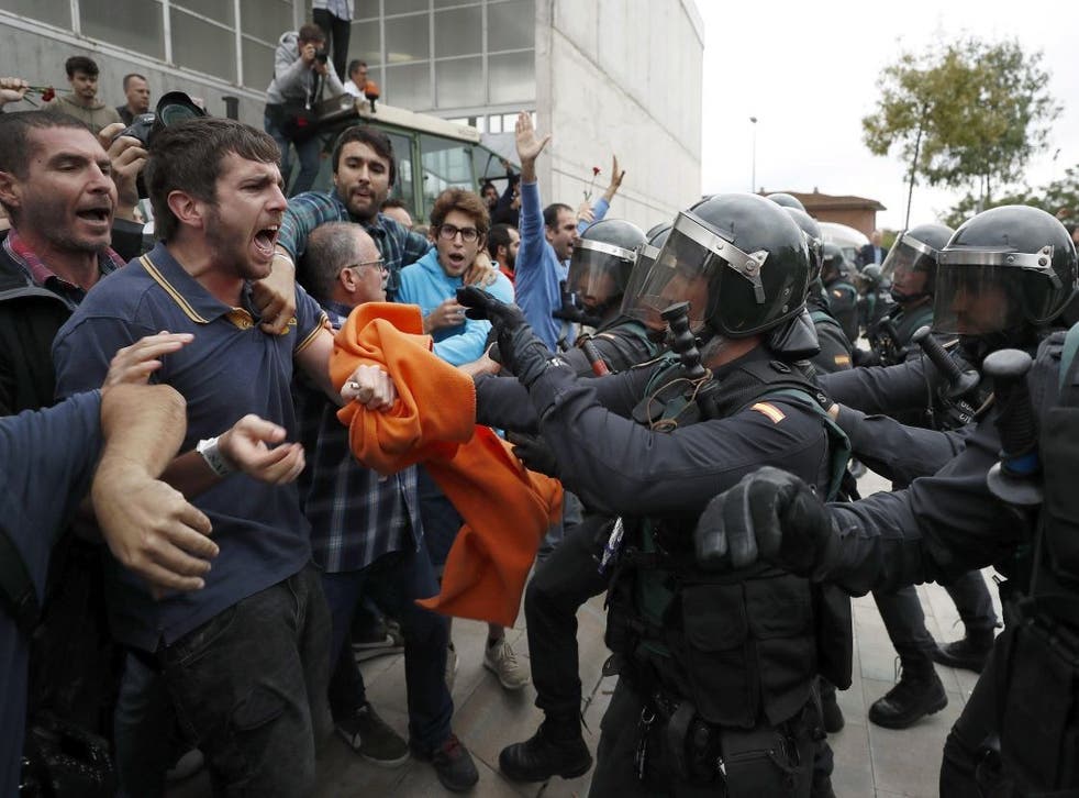 Pro-independence protesters clash with the civil guard outside a polling station in Girona