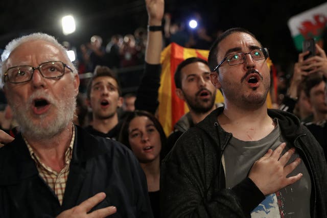People sing during a gathering at Plaza Catalunya after voting ended for the banned independence referendum, in Barcelona, Spain October 1, 2017
