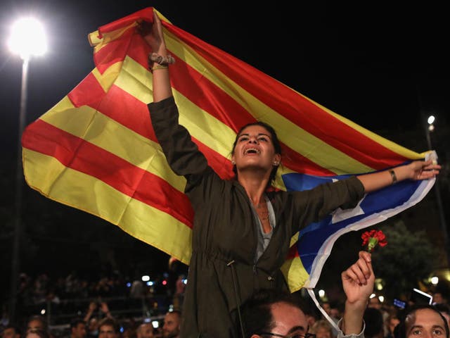 A woman holds aloft the Catalan flag at a demonstration