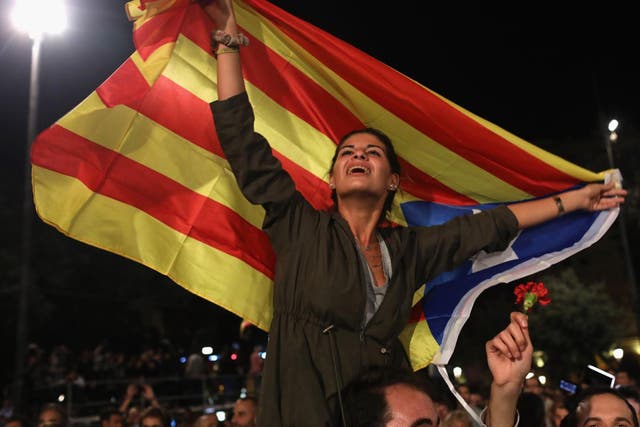 A woman holds aloft the Catalan flag at a demonstration