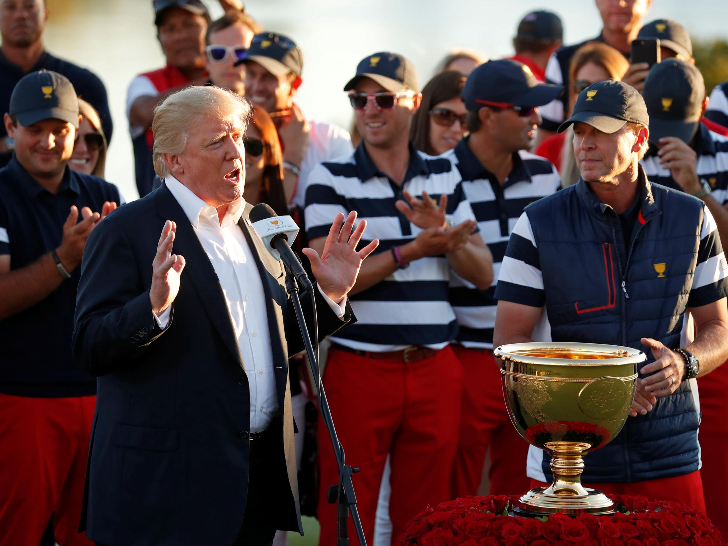 US President Donald Trump presents the trophy to the US team captain Steve Stricker at the conclusion of the Presidents Cup golf tournament at Liberty National Golf Club in Jersey City, New Jersey
