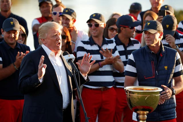 US President Donald Trump presents the trophy to the US team captain Steve Stricker at the conclusion of the Presidents Cup golf tournament at  Liberty National Golf Club in Jersey City, New Jersey