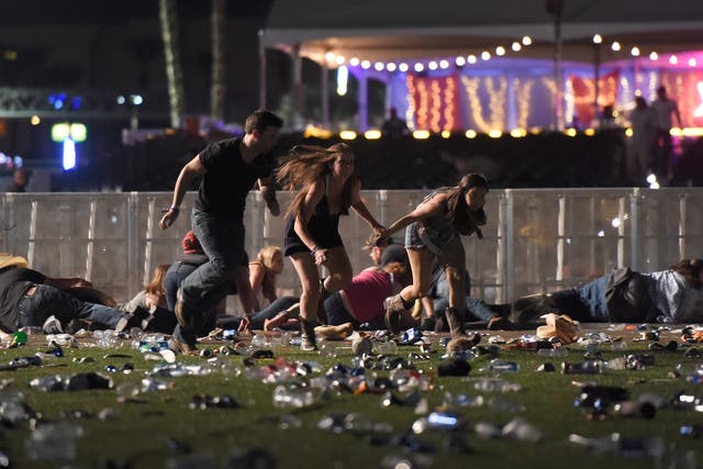 People run from the Route 91 Harvest country music festival in Las Vegas after a shooter opened fire