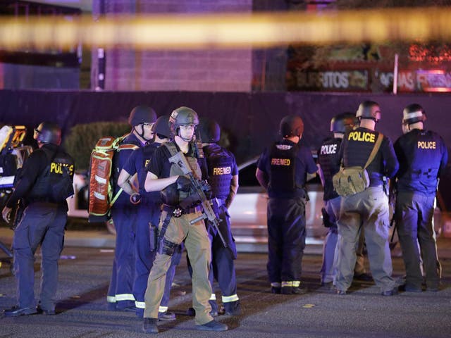 Police officers and medical personnel stand at the scene of a shooting near the Mandalay Bay resort and casino on the Las Vegas Strip, 2 October
