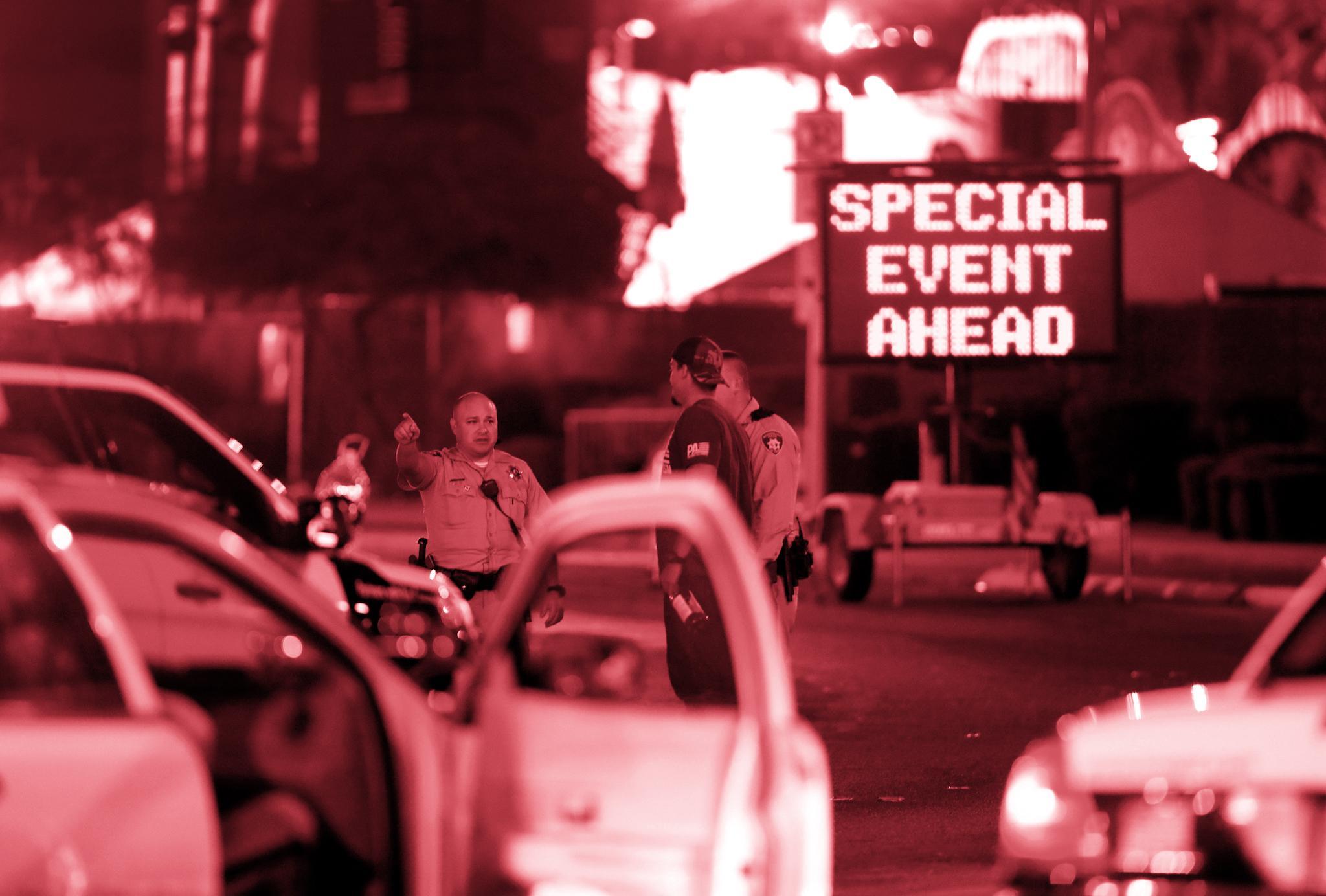 Metro Police officers speak with a man near the concert site on October 2, 2017, after a mass shooting during a music festival on the Las Vegas Strip in Las Vegas, Nevada