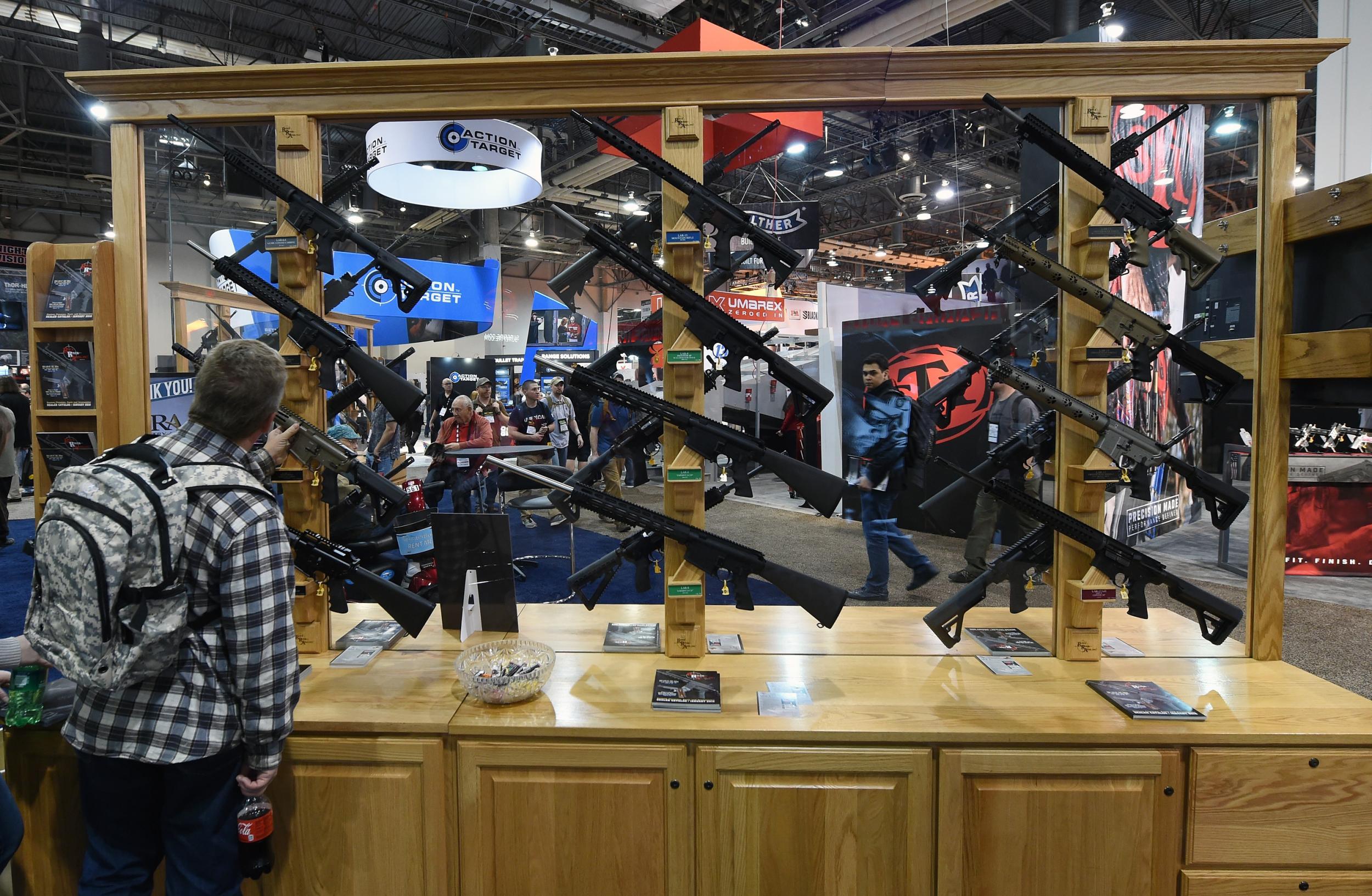 A convention attendee looks at rifles displayed at the Rock River Arms booth at the 2016 SHOT Show in Las Vegas