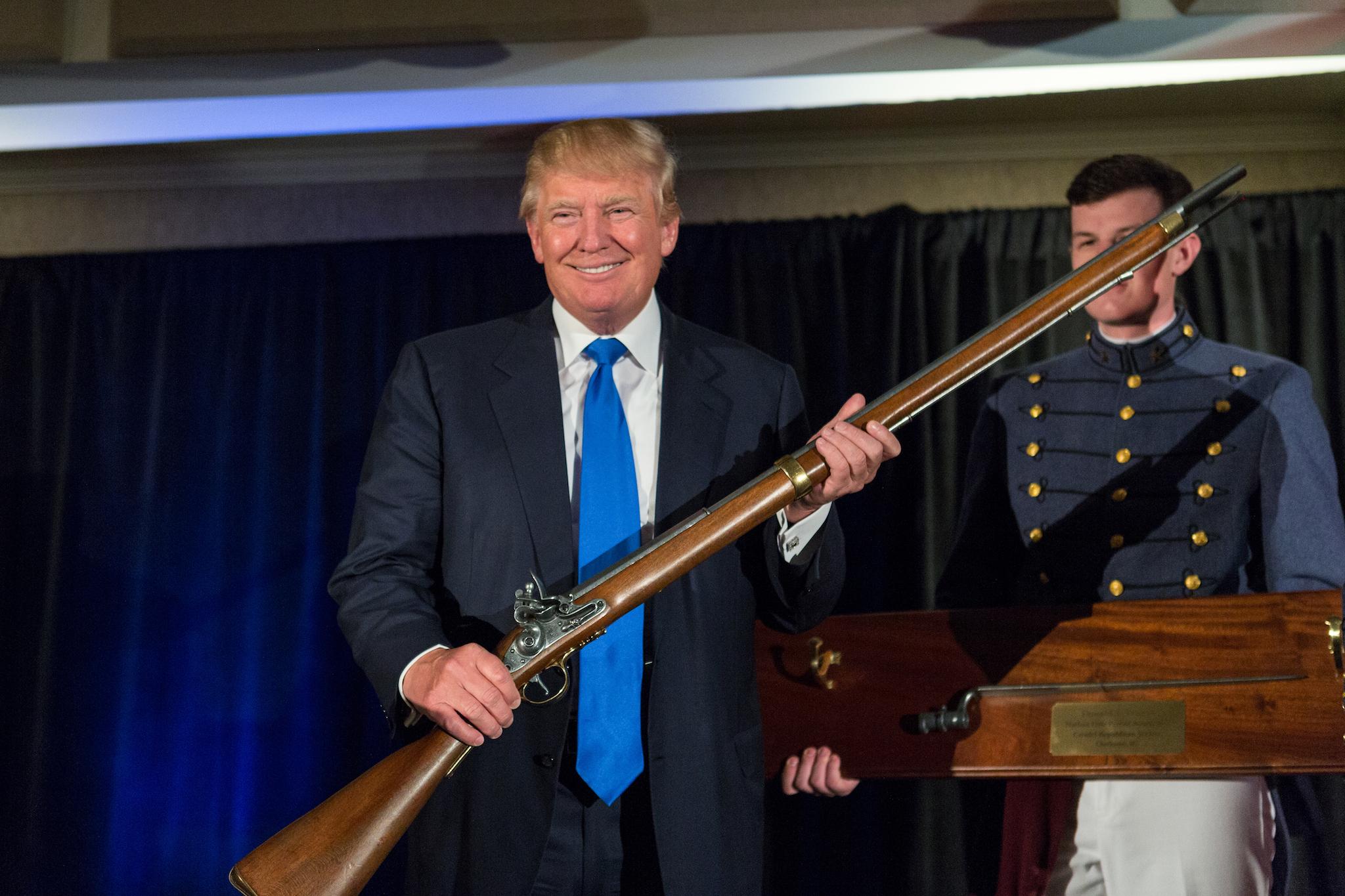 Donald Trump holds up a replica flintlock rifle awarded him by cadets