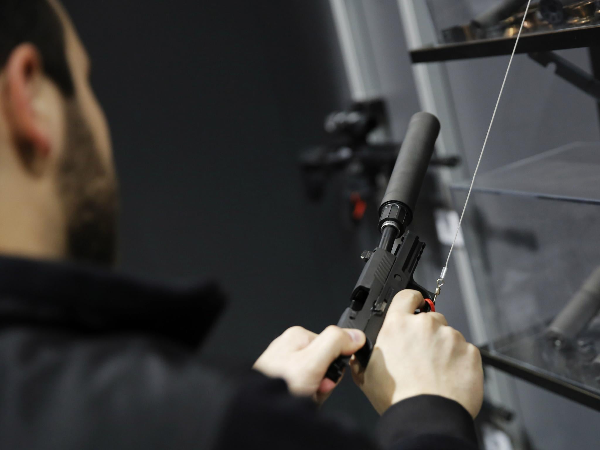 A visitors pulls the slide of a pistol with a silencer at a gun displays at a National Rifle Association outdoor sports trade show on 10 February 2017 in Harrisburg, Pennsylvania