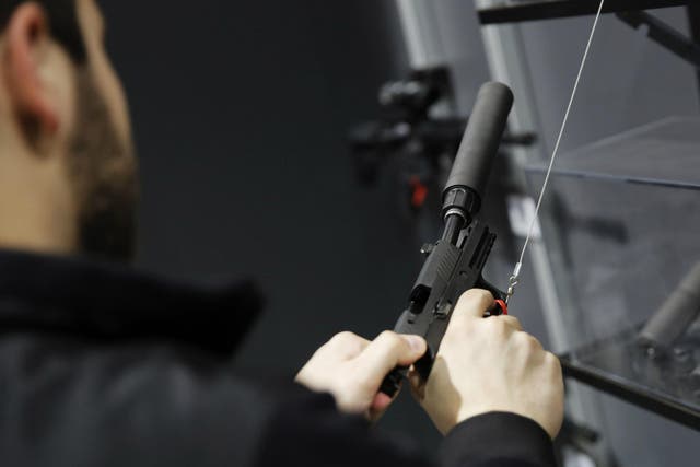 A visitors pulls the slide of a pistol with a silencer at a gun displays at a National Rifle Association outdoor sports trade show on 10 February 2017 in Harrisburg, Pennsylvania