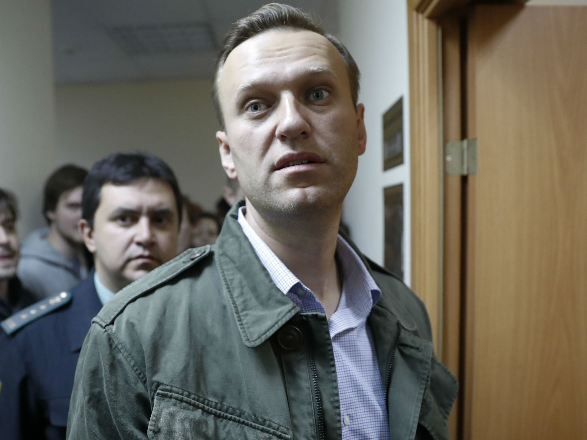 Alexei Navalny enters a court room in Moscow for his latest trial