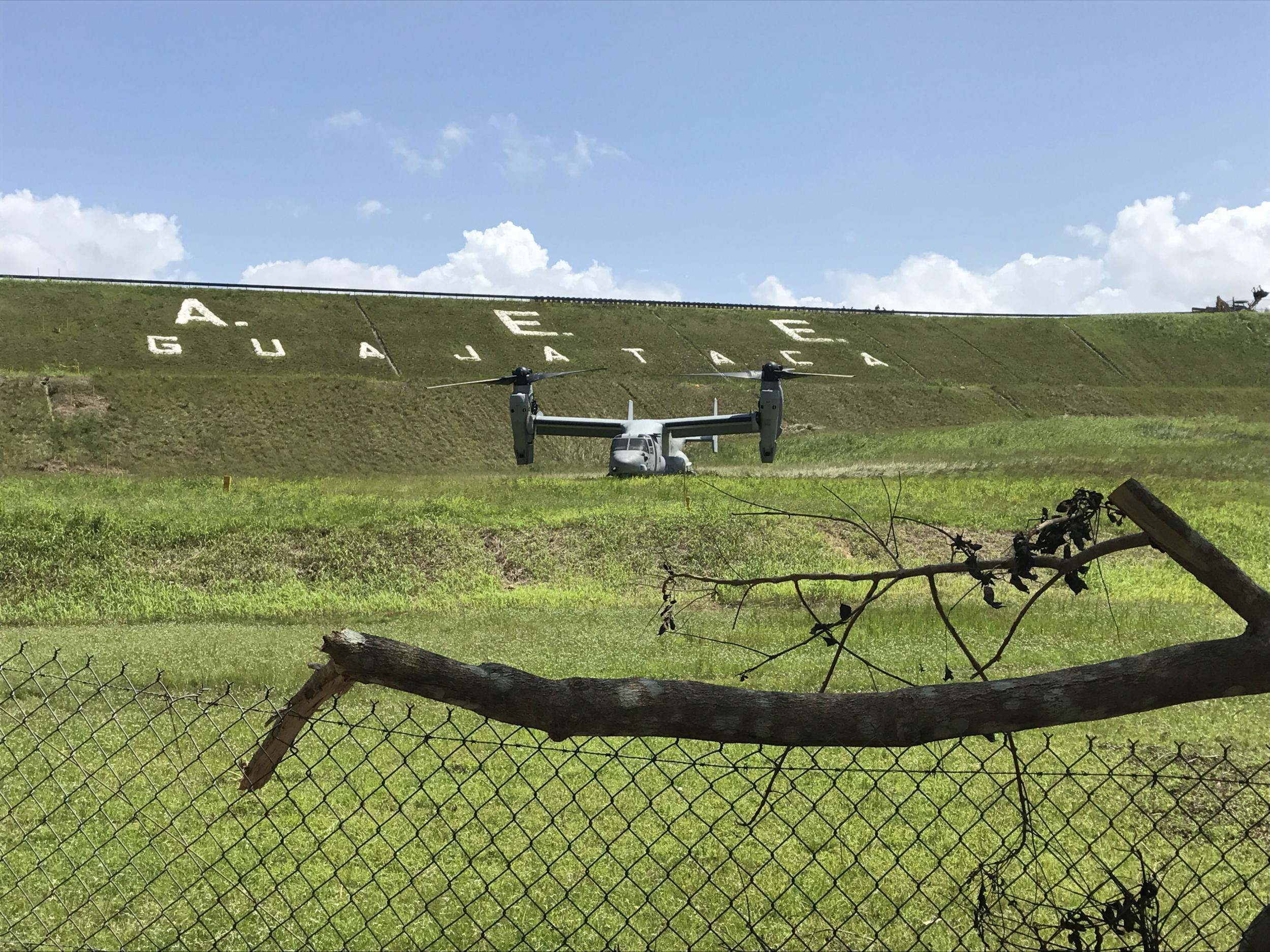 A US Marine Osprey waits below the dam to begin dropping ballast into damaged spillway