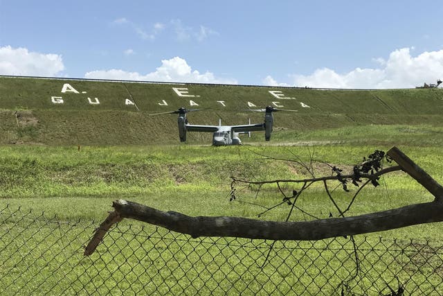 A US Marine Osprey waits below the dam to begin dropping ballast into damaged spillway