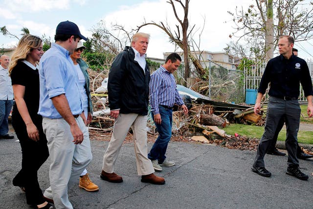 US President Donald Trump walks past hurricane wreckage as he participates in a walking tour with First Lady Melania Trump, Guaynabo Mayor Angel Perez Otero (second right) and Acting FEMA Administrator Brock Long (far right) as well as Puerto Rico Governor Ricardo Rossello (left) and his wife Beatriz Areizeaga in areas damaged by Hurricane Maria