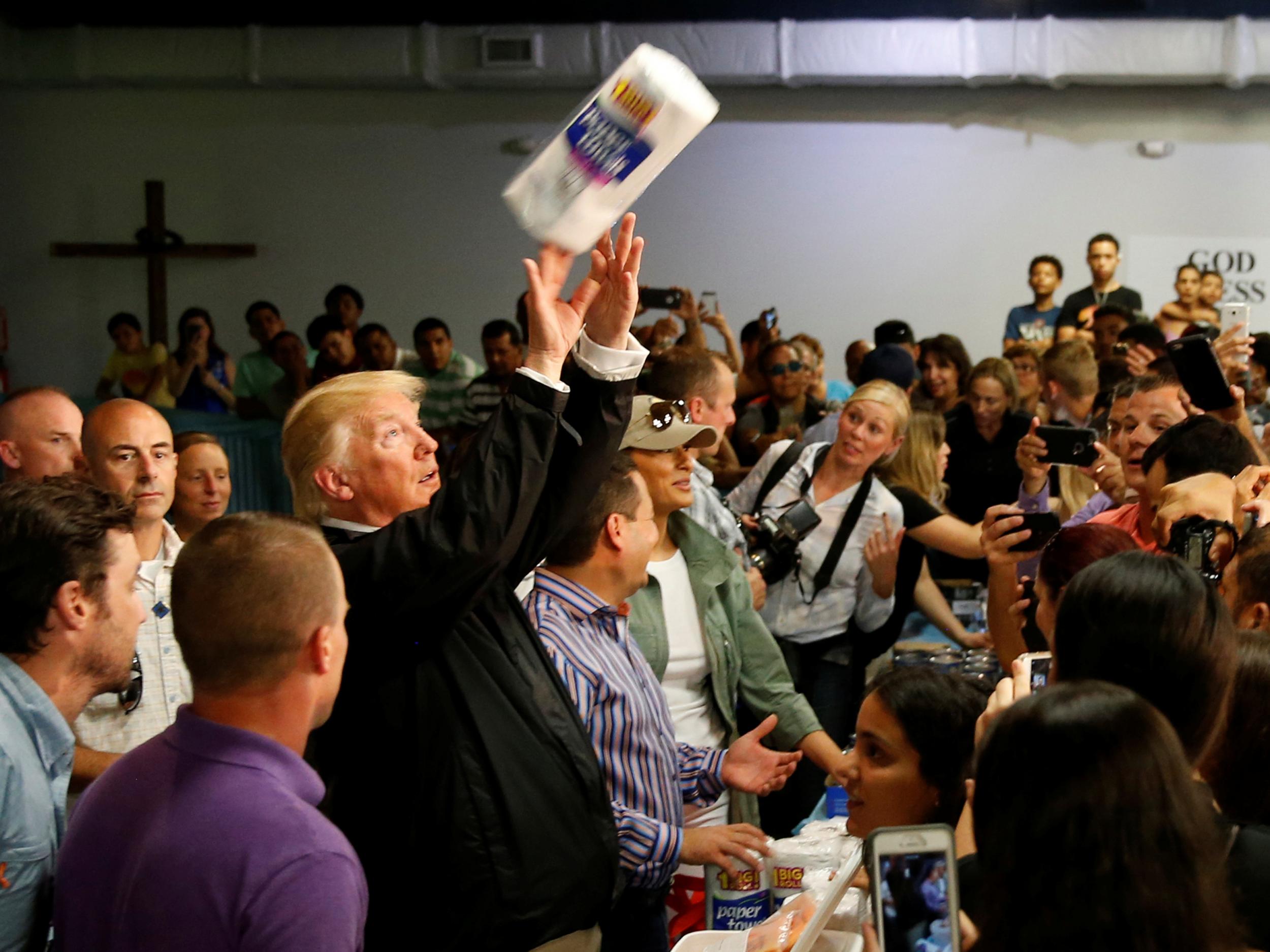 Trump tosses rolls of paper towels to people at a hurricane relief distribution centre at Calvary Chapel in San Juan (Reuters)