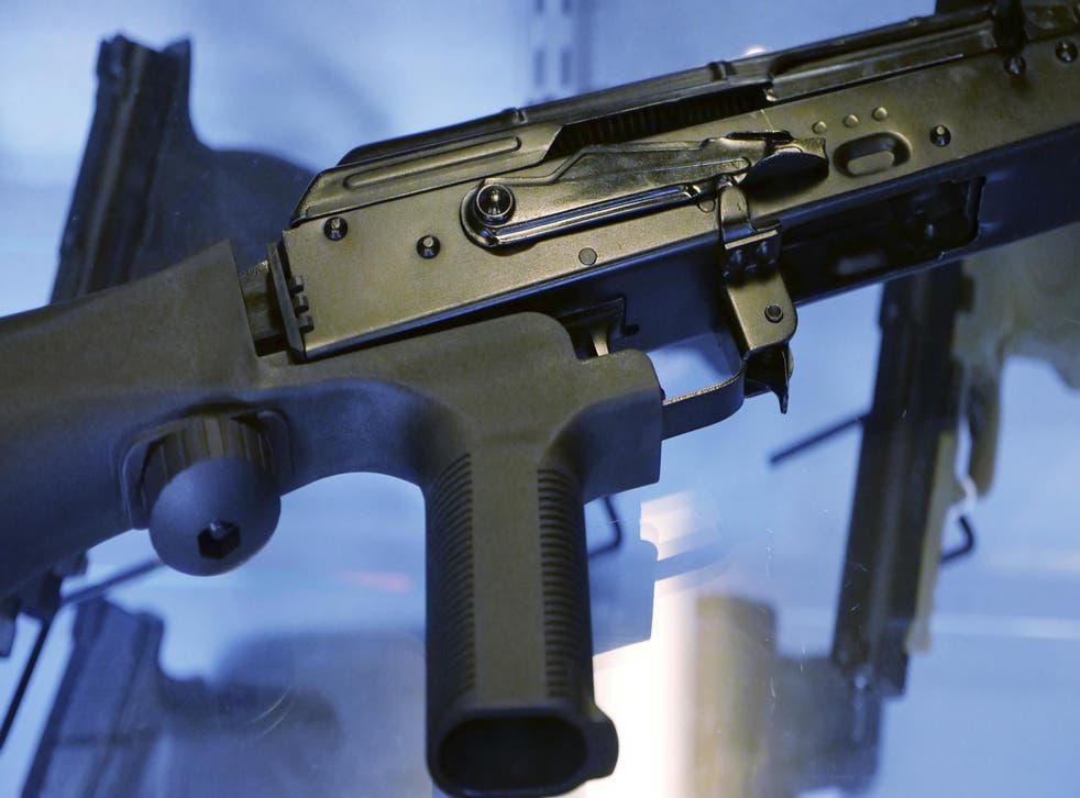 A little-known device called a "bump stock" is attached to a semi-automatic rifle at the Gun Vault store and shooting range