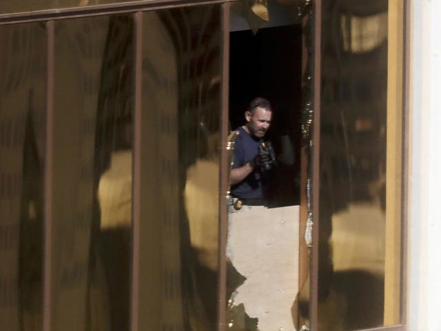 An investigator works in the room at the Mandalay Bay Resort and Casino from which a gunman opened fire on the crowd at the Route 91 Harvest music festival.