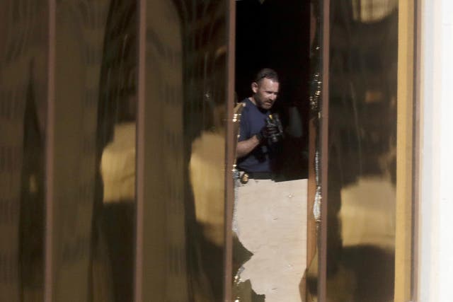 An investigator works in the room at the Mandalay Bay Resort and Casino from which a gunman opened fire on the crowd at the Route 91 Harvest music festival.