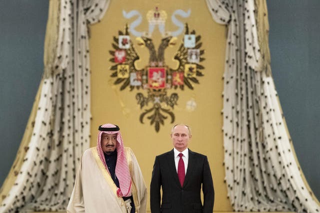 Saudi King Salman bin Abdulaziz and Russian President Vladimir Putin listen to national anthems during their meeting at the Kremlin