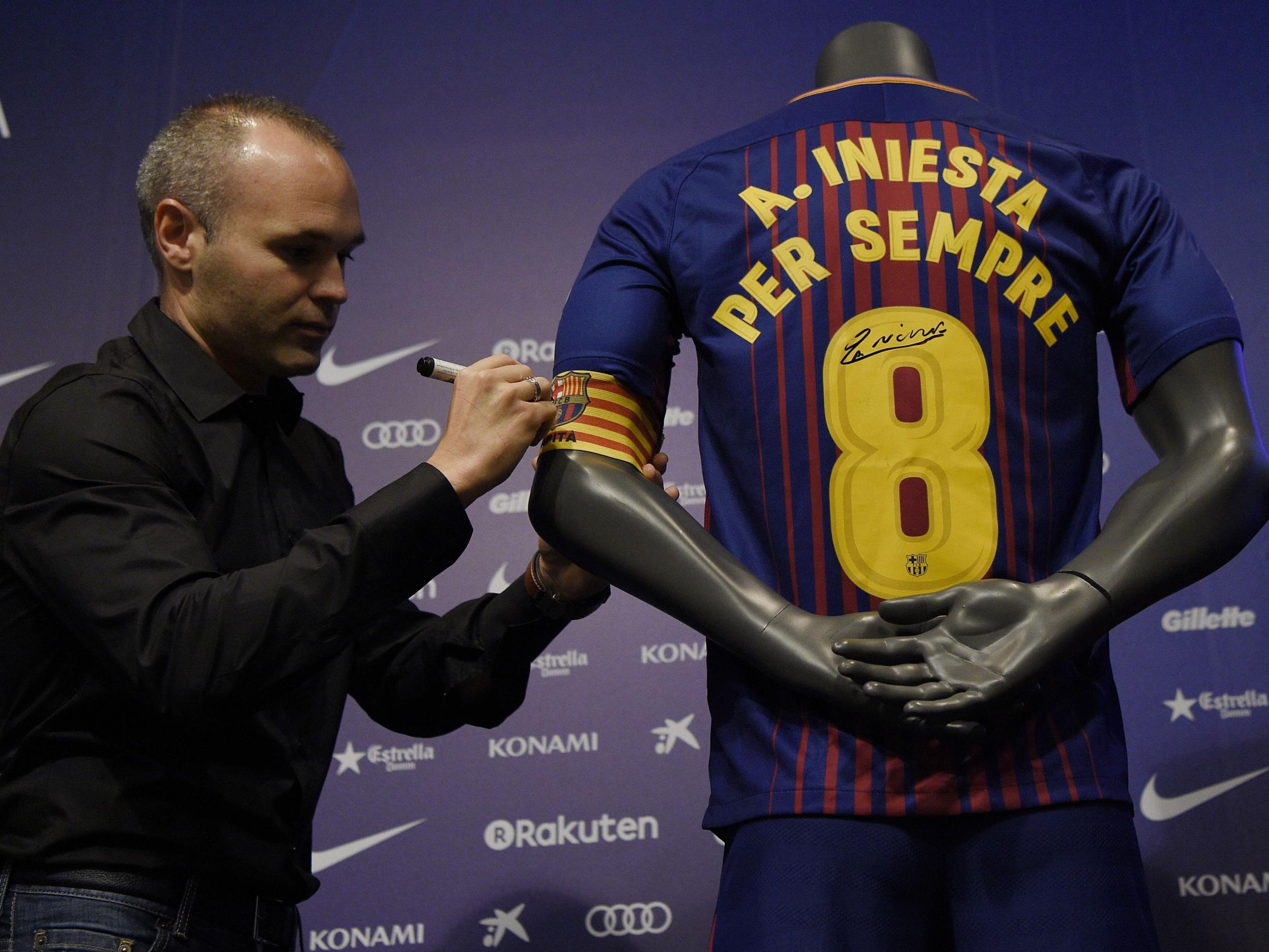 Andres Iniesta signs a shirt saying 'Iniesta forever'