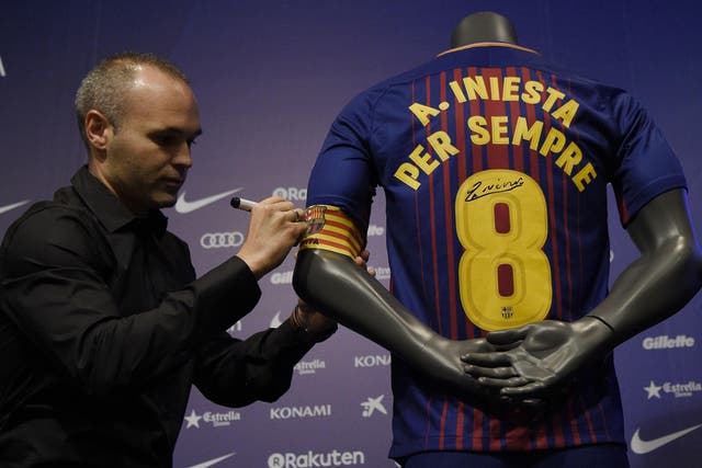 Andres Iniesta signs a shirt saying 'Iniesta forever'