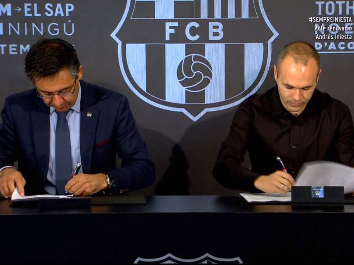 Iniesta signing his contract with Bartomeu
