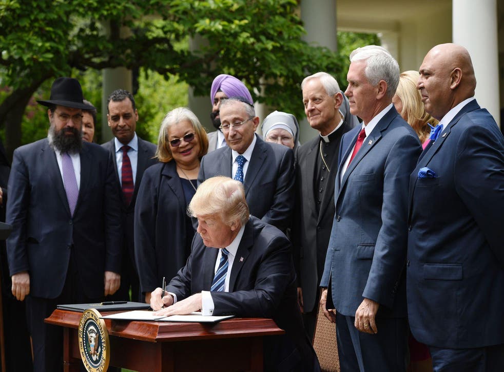 President Donald Trump signs an Executive Order on Promoting Free Speech and Religious Liberty in the Rose Garden of the White House on May 4, 2017