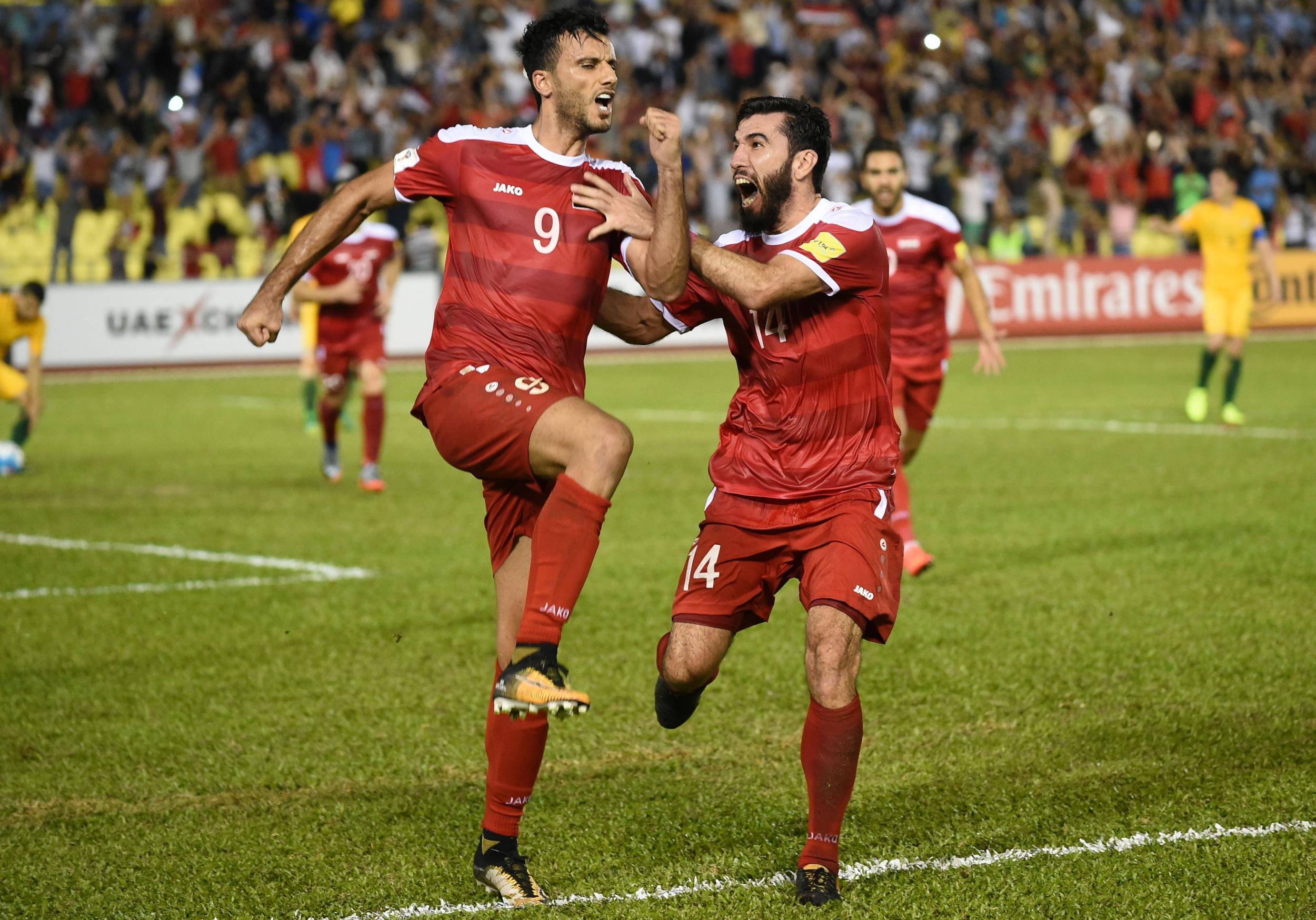 Omar Al Somah of Syria (left) celebrates his late equaliser from the penalty spot during Thursday’s World Cup qualifying match between Syria and Australia at the Hang Jebat Stadium in Malacca on 5 October 2017