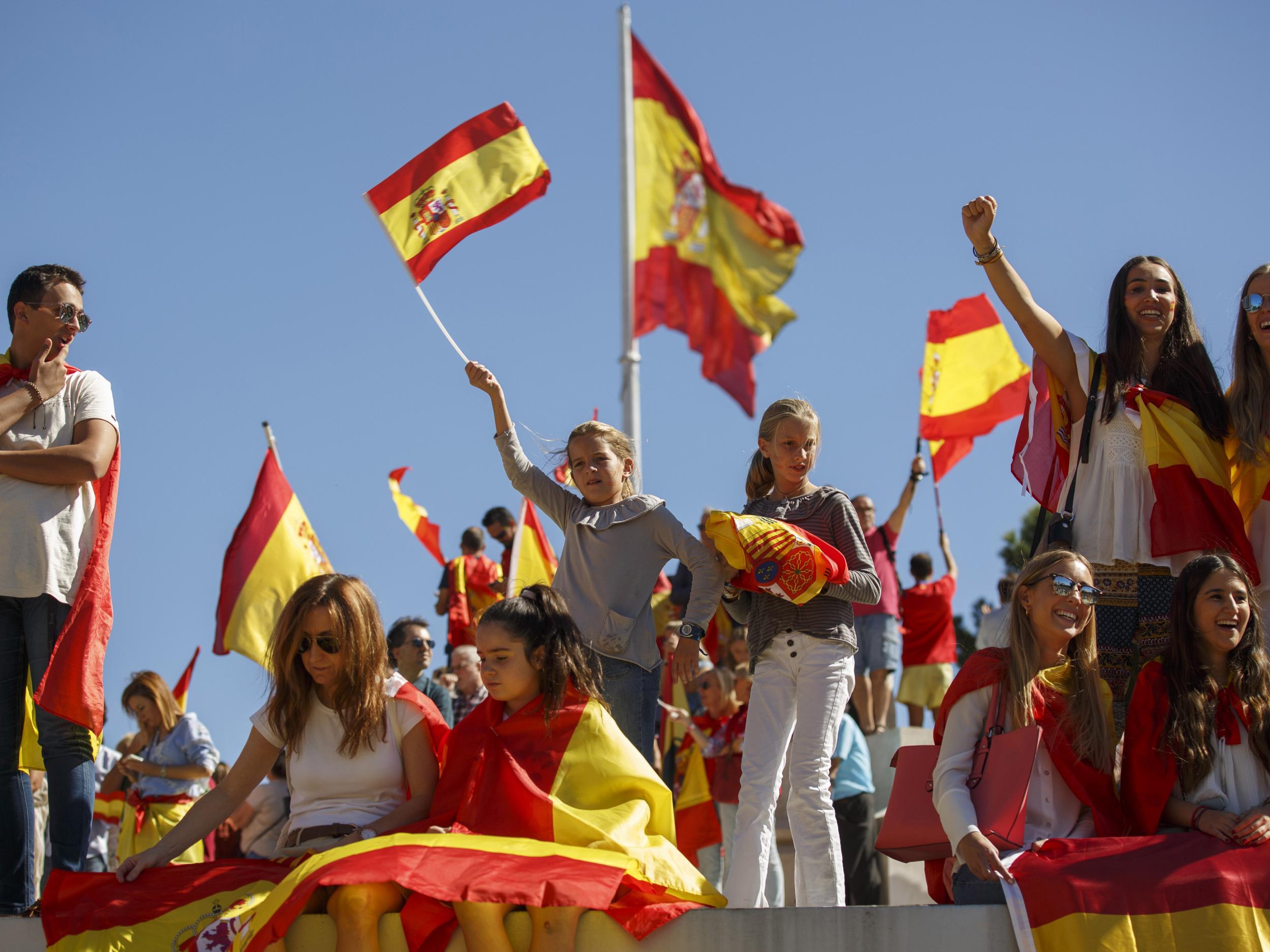 Pro-unity demonstrators hold Spanish flags during the rally called by the DANAES foundation at Colon Square in Madrid